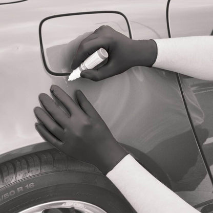 Person applying a product to a car mirror with gloves on
